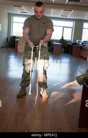 Sgt. Russell Blevins, ein Medic mit 1St Battalion, 179Th Infantry Regiment, 45th Infantry Brigade Combat Team, Oklahoma Army National Guard und ein Bewohner von Broken Arrow, Oklahoma, lehrt Ukrainischen Combat Training Center Mitarbeiter wie ein Schweizer Sitz als Kabelstrang für die Gunners Ausbildung an der internationalen Friedenssicherung und Security Center, in der Nähe der Yavoriv, Ukraine, am 13.02.10 mit Kabelbindern. (Foto von Sgt. Anthony Jones, 45th Infantry Brigade Combat Team) Stockfoto