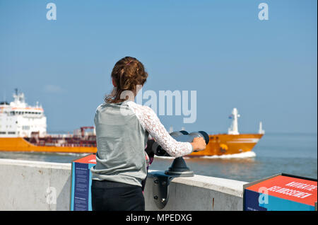 Ein junges Mädchen sieht in einem vorbeifahrenden Schiff, das Segel über dem westlichen Schelde Richtung Antwerpen Stockfoto