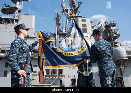 170216-N-XT 039-079 SASEBO, Japan (Feb. 16, 2017) Aviation Ordnanceman 2. Klasse Andrew Atchison, links, von Belton, Texas, Operations Specialist 2. Klasse Brendan Seehaver, rechts, von Canby, Erz. und Operations Specialist 2. Klasse Karlee Carter, von Redding, Kalifornien, Ravel eine Marine Flagge auf der Pier vor Amphibisches Schiff USS BONHOMME RICHARD (LHD6) während einer Räumungsübung Probe für eine bevorstehende Änderung der Befehl Zeremonie. Bonhomme Richard, Vorwärts- und Sasebo, Japan bereitgestellt, das eine schnelle Reaktionsfähigkeit im Falle eines regionalen Kontingenz oder natürlichen Disa zur Verfügung zu stellen Stockfoto