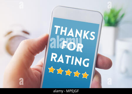 Vielen Dank für Bewertung Meldung auf Bildschirm des Smartphones in männlicher Hand. Customer Service Umfrage Feedback Konzept. Stockfoto