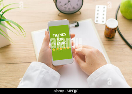 Vielen Dank für Bewertung Meldung auf Bildschirm des Smartphones bei weiblichen Arzt Hand. Patienten und Kunden Service Umfrage Feedback Konzept. Stockfoto