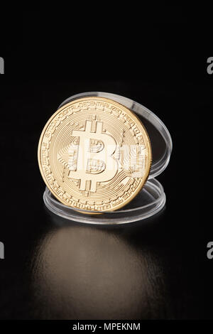 Golden bitcoin in transparenten Münze Container auf Schwarz, Freistellungspfad Stockfoto