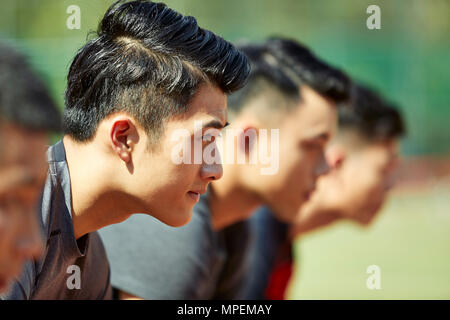 Nahaufnahmen der Gesichter von jungen asiatischen erwachsenen Läufer am Start. Stockfoto