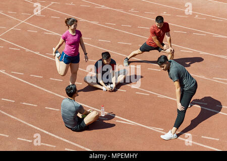 Gruppe von jungen asiatischen Sportler stretching Entspannen am Anschluss vor dem Training. Stockfoto