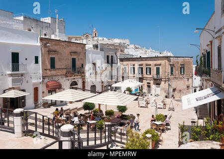 Touristen im Freien essen in einem Restaurant in Ostuni, Puglia, Italien. Stockfoto