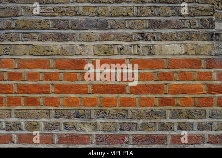 Nahaufnahme von einer Backsteinmauer, mit Schichten von roten und gelben Backsteinen, ein ausgezeichneter Hintergrund gedreht. Stockfoto