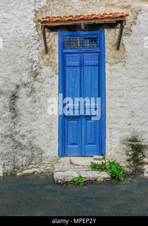 Altes Gebäude mit interessanten blaue Türen, die geschlossen sind. Lebendige in der Farbe Blau und einem Grill Muster an der Spitze, die durch einen kleinen Fliesen- Dach bedeckt. Stockfoto