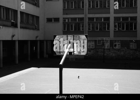 Baskettballplatz draußen auf dem Schulhof. Schwarz-weiß Foto. Städtische Einstellung. Stockfoto