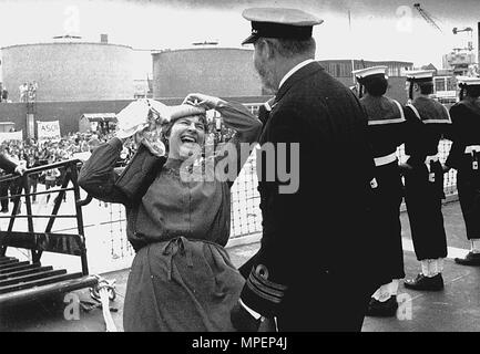 DIE FRAU DES SKIPPERS DER HMS HYDRA SHONA CAMPBELL BEGRÜSST IHREN EHEMANN KOMMANDANT RICHARD CAMPBELL, ALS HMS HYDRA NACH PORTSMOUTH AUS DEM FALKLANDKRIEG ZURÜCKKEHRTE. 1982 Stockfoto