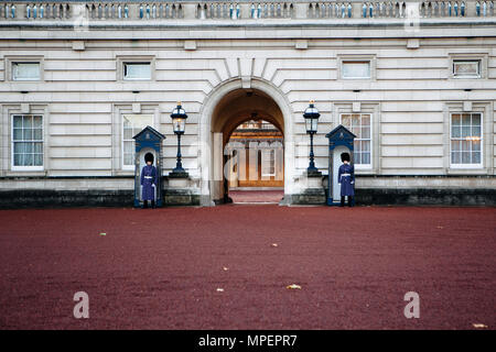 Zwei Wachen stehen an Aufmerksamkeit vor dem Buckingham Palace. Stockfoto