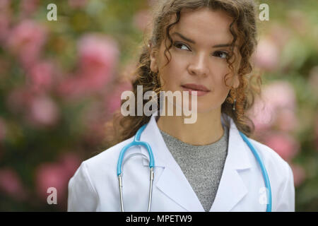 Porträt einer jungen Frau Student der Medizin mit kontemplativen nachdenklichen Blick, wenn man bedenkt, dass eine Karriere in der natürlichen Medizin, Gesundheitswesen, Arzt, Arzt. Stockfoto