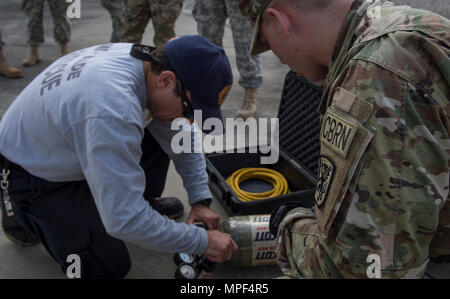 Lt. Chris Pecori (links), Miami-Dade Fire Rescue Air Rescue Training Officer, beauftragt Druckluftschlauch Nutzung zur U.S. Army Reserve Sgt. Ryan Garvey, 329 Unternehmen der Chemischen Industrie chemische biologische Kriegsführung Spezialist, während Gefahrgut Ausbildung auf Dade Feuerwehr Hauptquartier, Miami, FL. Feb 17, 2016. Das Training war Feuerwehr Personal, das Soldaten und Ersthelfern eine Erhöhung der Interoperabilität bei der chemischen und radiologischen Ereignissen geführt. (U.S. Air Force Foto: Staff Sgt. Cory D. Payne) Stockfoto