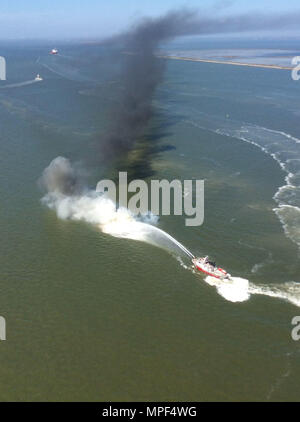 Zwei Hafen von Houston Feuer Boote eine versenkte 44-Fuß-Sport Angeln Boot im Houston Ship Channel in der Nähe von Licht 63, ca. 6 km östlich von Kemah, Texas, Samstag, Februar 18, 2018 löschen. Ein Coast Guard Station Galveston Crew gerettet die zwei Personen, die an Bord der brennenden Schiff waren, bevor sie in Flammen eingehüllt wurde. U.S. Coast Guard Foto von Leutnant Josua Scritchfield. Stockfoto