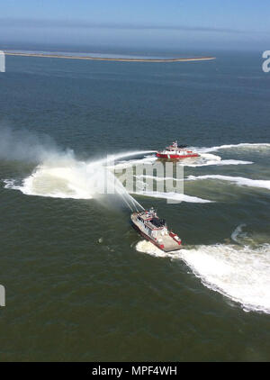 Zwei Hafen von Houston Feuer Boote eine versenkte 44-Fuß-Sport Angeln Boot im Houston Ship Channel in der Nähe von Licht 63, ca. 6 km östlich von Kemah, Texas, Samstag, Februar 18, 2018 löschen. Ein Coast Guard Station Galveston Crew gerettet die zwei Personen, die an Bord der brennenden Schiff waren, bevor sie in Flammen eingehüllt wurde. U.S. Coast Guard Foto von Leutnant Josua Scritchfield. Stockfoto