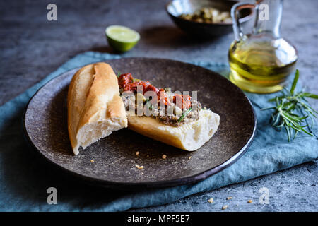 Baguette mit Camembert, Tapenade und getrocknete Tomaten Stockfoto