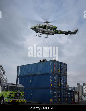 Feuerwehrmänner mit dem Miami-Dade Fire Rescue Department Antwort auf ein Szenario auf einer gemeinsamen Gefahr material Übung im Hafen von Miami, Feb 18, 2017. Die Abwehr chemischer, biologischer, radiologischer und nuklearer Response Force Übung bewirtet durch MDFR und die miami-dade Port Authority der U.S. Army Reserve 329 Chemical Company, 469th der Armee finden im Krankenwagen, umgegeben von Wichita, Kan., und der Zivilgesellschaft des Florida National Guard Support Team. (U.S. Armee finden Foto von Master Sgt. Marisol Walker/Freigegeben) Stockfoto