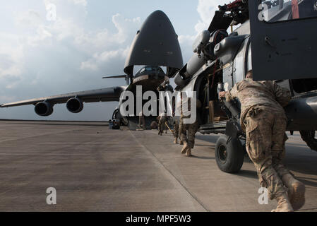 Flieger an die 823 Maintenance Squadron Last zugewiesen wird, um ein HH-60G Pave Hawk vom 66th Rescue Squadron in eine C-5 M Super Galaxy von Dover Air Force Base, Arizona, auf der Flightline im Al Asad Air Base, Irak, 13.02.2017. Der rescue Squadron war eine Umschichtung auf der Nellis Air Force Base, Nevada, nachdem er als einer der Einheiten, aus denen sich eine Mehr-als-60-nation Koalition kämpfen ISIS. CJTF-OIR ist die globale Koalition zu besiegen ISIS im Irak und in Syrien. (U.S. Air Force Foto/Master Sgt. Benjamin Wilson) Stockfoto