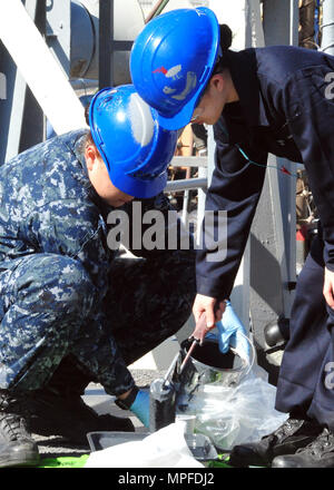 170222-N-YG 414-261 Yokosuka, Japan (Feb. 22, 2017) - Seemann Sarah Senato, Links, und Seaman Apprentice Pangkov Thao, beide in die USA 7 Flotte Flaggschiff USS Blue Ridge LCC (19), Paint Bereichen Main Deck des Schiffes angebracht. Blue Ridge ist in eine umfassende Wartung, um das Schiff weiterhin als eine robuste Kommunikation Plattform in den USA 7 Flotte Einsatzgebiet zu dienen zu modernisieren. (U.S. Marine Foto von Mass Communication Specialist Seaman Patrick Semales/freigegeben) Stockfoto
