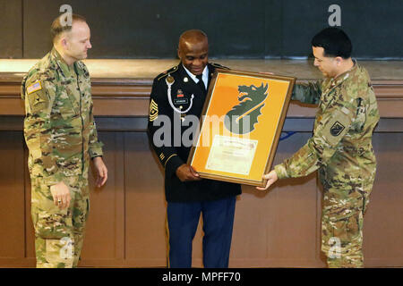 Us-Armee Oberst Rob Parker (links), Kommandant der 5. Signal (Theater) und Command Sgt. Maj Frank Gutierrez, 5th Signal Command (Theater) Senior Berater angeworben, präsentieren eine Bescheinigung der Anerkennung und Plakette zu Sgt. Maj. Robert Atkinson, die US-Army Europe G-1 Sergeant Major, für das Sprechen an der US-Armee Garnison Wiesbaden Gemeinschaft Black History Month Einhaltung Feb 15, 2017 Im Tony Bass Auditorium auf Lehm Kaserne. Atkinson sprach über die Geschichte des 25. Infanterie Division Fahrrad Corps, ein in erster Linie schwarze Einheit, die Tests für die Armee über die Durchführbarkeit der ig durchgeführt. Stockfoto