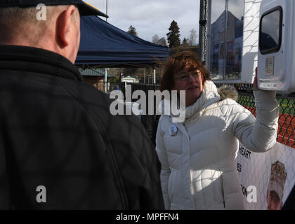 170224-N-LQ 926-074 Everett, Washington (Feb. 24, 2017) Laurie Finlayson, Executive Director, Lion Heart Held-grundlage, liest eine Widmung Plakat während einer automatisierten externen Defibrillator Einweihung an der Naval Station Everett Leichtathletik. Zu Ehren von Lance Cpl. David Finlayson, der im Alter von 25 Jahren an plötzlichem Herzstillstand während fünf - Meile Training mit seinem Bataillon in Hawaii run starb, der Lion Heart Helden will die Stiftung Gesundheit des Herzens in der militärischen Gemeinschaft zu fördern. (U.S. Marine Foto von Mass Communication Specialist 2. Klasse Alex Van't Leven/Freigegeben) Stockfoto