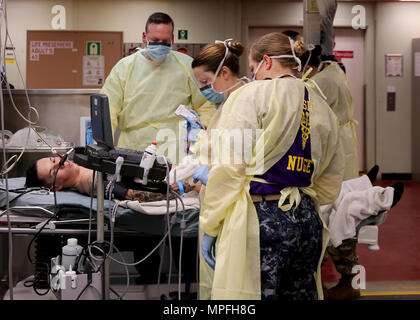 170222-N-OH 262-167 ATLANTIK (22. Februar 2017) - - USA Marine medizinische Fachleute, angeschlossen an das Krankenhaus ship USNS Comfort (T-AH 20), Vorbereiten einer Notoperation auf einem simulierten Gefecht casulty während einer Messe Unfallversicherung bohren durchzuführen, 24.02.22. Die Masse Unfallversicherung bohren war Teil des Schiffes Komfort Übung (COMFEX). (U.S. Marine Foto von Bill Mesta/freigegeben) Stockfoto