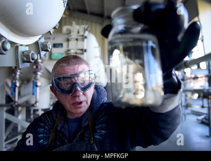 Darryl Hodge, 733Rd Logistik Bereitschaft Squadron Brennstoffe Einrichtungen Brennstoffe Vertriebssysteme operator, nimmt eine Kraftstoffprobe am Joint Base Langley-Eustis, Virginia, 10. April 2017. Neben den Auswirkungen auf die flightline Operationen, Kraftstoffe auch sicherzustellen, dass staatliche Fahrzeuge auf Basis mit Kraftstoff- und Gebäuden zur Verfügung gestellt werden, sind mit geschliffenen Produkten Sie viele brauchen, einschließlich Benzin, Standard schwefelarmen Diesel und Biodiesel, das ist umweltfreundlicher geliefert. Stockfoto