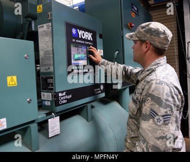 Us Air Force Senior Airman Brandon Fleury, 7 Tiefbau Squadron Heizung, Lüftung und Klimaanlage Facharbeiter, passt die Steuerelemente auf einer zentrifugalen Kaltwassersatz in Dyess Air Force Base, Texas, 6. März 2017. Dieser Kühler ist eines von sechs, die eine große Anzahl von Gebäuden auf der Basis bei einer angenehmen Temperatur halten, während noch energieeffizient. (U.S. Air Force Foto von älteren Flieger Alexander Guerrero) Stockfoto