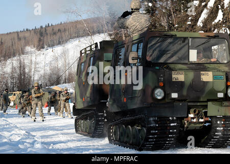 Soldaten skijour hinter einer kleinen Einheit Unterstützung Fahrzeug als Teil der US-Armee Alaska Winter Spiele am Fort Wainwright, Alaska, 9. März 2017. Veranstaltungen in diesem Jahr gehören Downhill Ski Racing, live-fire biathlon Range, Stress schießen, land Navigation, Skijöring, Einrichten der Arktis 10-Mann Zelt und Herd richtig, und die Bewertung und Behandlung von einem Unfall in der extremen Kälte. Als Amerika's Arctic Krieger und Experten der US-Armee in Überlebenden, Betrieb, kämpfen und gewinnen in extrem kalten Wetter und Höhenlage Umgebungen, alle Fertigkeiten, die während der Spiele getestet sind kritisch für alle USARAK S Stockfoto