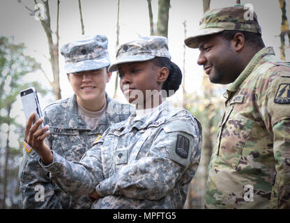 U.S. Army Reserve SPC. Irelin Odonnell (links), SPC. Breatta Kran (Mitte) und Pfc. Carlton Ashley, allen Fachkräften für die Zentrale und die Konzernzentrale, 335.- Signal (Theater), nehmen Sie sich einen Augenblick Zeit, ein Lachen, ein Video auf dem Telefon des Kran, um während einer Pause an Autofahrer Ausbildung bei Sykes Park im Osten, Georgien, März 10 Teilen. Die Schulungsveranstaltung, lehrte fast 10 Armee Reservisten Fertigkeiten zur Sicherheit betreiben ein Humvee und ein Light Medium Tactical Vehicle (LMTV), und es war das erste seiner Art, veranstaltet von der 335 SC (T). Cpl. Eric Adcock, der Trainer Stockfoto