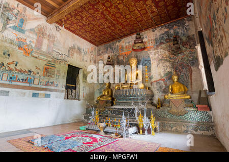 Wandbilder, Altar und Buddha Statuen im Innern des Wat Pa Huak Tempel in Luang Prabang, Laos. Stockfoto