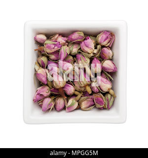 Getrockneten französischen Rosebuds In a square Schüssel auf weißem Hintergrund Stockfoto