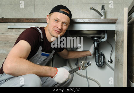 Arbeitnehmer setzt Falle für die küchenspüle. w Stockfoto