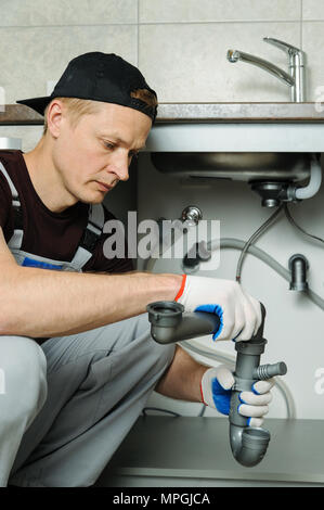 Arbeitnehmer setzt Falle für die Küchenspüle. Stockfoto