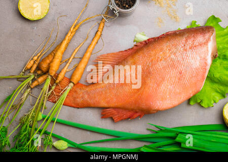 Rotes Meer Zander mit Gemüse auf den Tisch mit jungen Karotten, Gewürze, Kalk, grüne Zwiebeln Stockfoto
