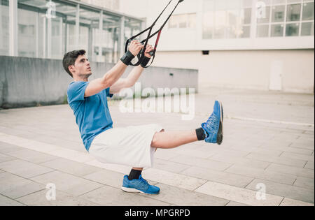 Sportlich männlich Trainieren mit Fitness trx Träger auf der Straße Stockfoto