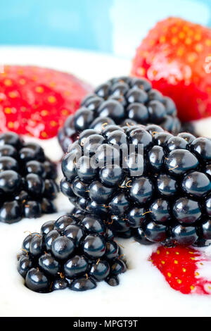 In der Nähe Bild von Brombeeren, Erdbeeren im Joghurt, geringe Tiefenschärfe. Stockfoto