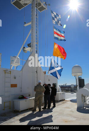 170220-N-OH 262-285 Norfolk, Virginia (20. Februar 2017) -- Öffentlichen Dienst Seemänner an Military Sealift Command's Hospital Ship USNS Comfort (T-AH 20) untere Signal flags, wie das Schiff unterwegs erhält von der Naval Station Norfolk, 24.02.20. Das Schiff erhielt unterwegs zu leiten, seinen Komfort Übung (COMFEX). (U.S. Marine Foto von Bill Mesta/freigegeben) Stockfoto