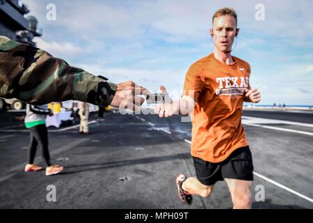 170226-N-MJ 135-302 PAZIFISCHEN OZEAN (Feb. 26, 2017) Senior Chief Information Systems Techniker Joshua Hoffman sammelt eine Karte während der Poker Run" auf dem Flugdeck der Flugzeugträger USS Theodore Roosevelt (CVN 71). Theodore Roosevelt ist derzeit vor der Küste von Südkalifornien die Durchführung von routinemäßigen Ausbildungsmaßnahmen. (U.S. Marine Foto von Mass Communication Specialist 3. Klasse Spencer Roberts/Freigegeben) Stockfoto