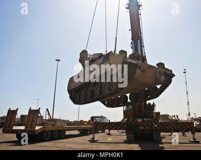 Ein M2/M3 Bradley Fighting Fahrzeug per Kran auf einen Tieflader auf die usns Mendonca an Shuaiba Port, Kuwait, am 28.02.2017, transportiert. Die mendonca Dient zum Importieren und US-Militär Fahrzeuge zur Unterstützung von Maßnahmen in der USCENTCOM AOR exportieren. (U.S. Armee Foto: Staff Sgt. Dalton Smith) Stockfoto