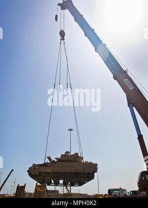 Ein M2/M3 Bradley Fighting Fahrzeug per Kran auf einen Tieflader auf die usns Mendonca an Shuaiba Port, Kuwait, am 28.02.2017, transportiert. Die mendonca Dient zum Importieren und US-Militär Fahrzeuge zur Unterstützung von Maßnahmen in der USCENTCOM AOR exportieren. (U.S. Armee Foto: Staff Sgt. Dalton Smith) Stockfoto