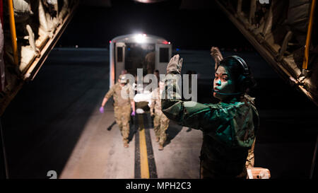 1. Lt. Sarah Jun, 455Th Aeromedical Evacuation Squadron Flug Krankenschwester, leitet Wurf Träger bringen einen Patienten an Bord einer C-130 J Hercules ihn aus Kandahar regionale militärische Krankenhaus, Kandahar Airfield zu transportieren, in der Craig gemeinsame Theater Krankenhaus, Bragram Flugplatz, Afghanistan Feb 22, 2017. Die 455Th EAES erstellt und betreibt einen tragbaren Intensivstation an Bord des Flugzeugs, die Ihnen ermöglicht, sich kritisch verletzten oder erkrankten Patienten zu einem höheren Maß an Pflege zu transportieren. (U.S. Air Force Foto: Staff Sgt. Katherine Spessa) Stockfoto