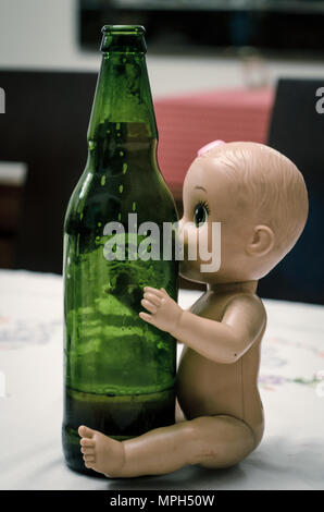 Puppe sitzend umarmen Bierflasche, Konzept Bild Stockfoto