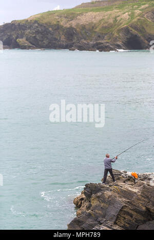 Ein einsamer Angler Angeln vom Felsen in Newquay in Cornwall. Stockfoto