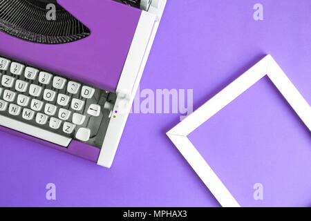 Retro Vintage Schreibmaschine und Bilderrahmen violett minimal kreatives Konzept. Stockfoto