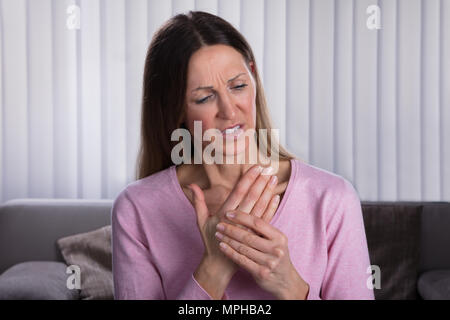 In der Nähe des Umgekippten Frau von Palm Schmerzen zu Hause Leiden Stockfoto