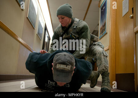 Air Force Staff Sgt. Brittney Howard, ein streifenpolizist mit der 673 d Security Forces Squadron Pins nach unten und hält Air Force Master Sgt. Daniel Chrisco, eine aktive Shooter übung Player, in der 773Rd Bauingenieur Squadron, März 13. Die Sicherheitskräfte Geschwader auf gemeinsamer Basis Elmendorf-Richardson führt regelmäßig keine - Bekanntmachung der Tests der aktiven shooter Mentalitäten Büros' um. (U.S. Air Force Foto von älteren Flieger Kyle Johnson) Stockfoto