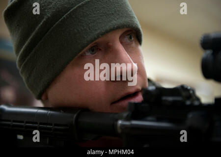 Air Force Staff Sgt. Nicholas Woolridge, ein streifenpolizist mit der 673 d Security Forces Squadron Uhren der Flur als seine Mitarbeiter löscht den nächsten Raum in der 773Rd Bauingenieur Squadron, März 13. Die Sicherheitskräfte Geschwader auf gemeinsamer Basis Elmendorf-Richardson führt regelmäßig keine - Bekanntmachung der Tests der aktiven shooter Mentalitäten Büros' um. (U.S. Air Force Foto von älteren Flieger Kyle Johnson) Stockfoto