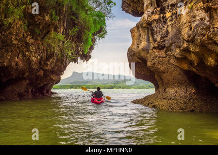 Kajak unter hohen Klippen in Thailand Stockfoto