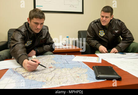 Kapitän Brett Boudreaux, Links und Kapitän Scott Robinson, sowohl zur 22 Airlift Squadron zugewiesen ist, klicken Sie auf den Flugplan für die Sendung der Tag von OSAN FLUGHAFEN, Südkorea, Yokota Air Base, Japan, 9. März 2017. Die Piloten wurden auf einer pazifischen Kanal mission Flying Cargo von Osan Flughafen ab zu Travis Air Force Base, Kalifornien. (U.S. Air Force Foto: Staff Sgt. Nicole Leidholm) Stockfoto