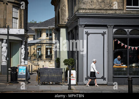 Frau zu Fuß entlang der Straße im Stadtteil Montpellier Cheltenham, Gloucestershire. Stockfoto